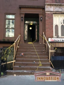 Worker applying waterproofing treatment to brownstone exterior