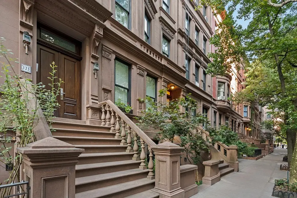 Brownstone townhouse exterior in New York City showing traditional architecture and landscaped front yard