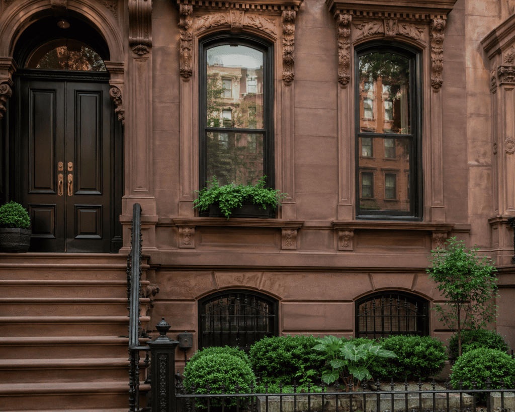 Upper West Brownstone Restoration showing a restored historic brownstone facade with detailed stonework, stoop, and closely spaced row houses in Manhattan, NYC.